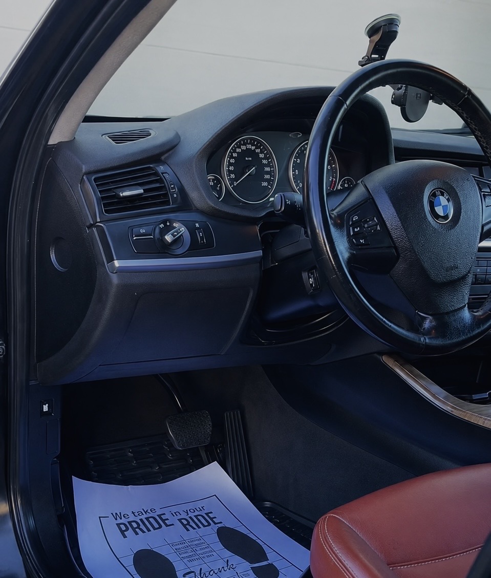 Freshly detailed BMW interior with a K.S Customs thank-you floor mat